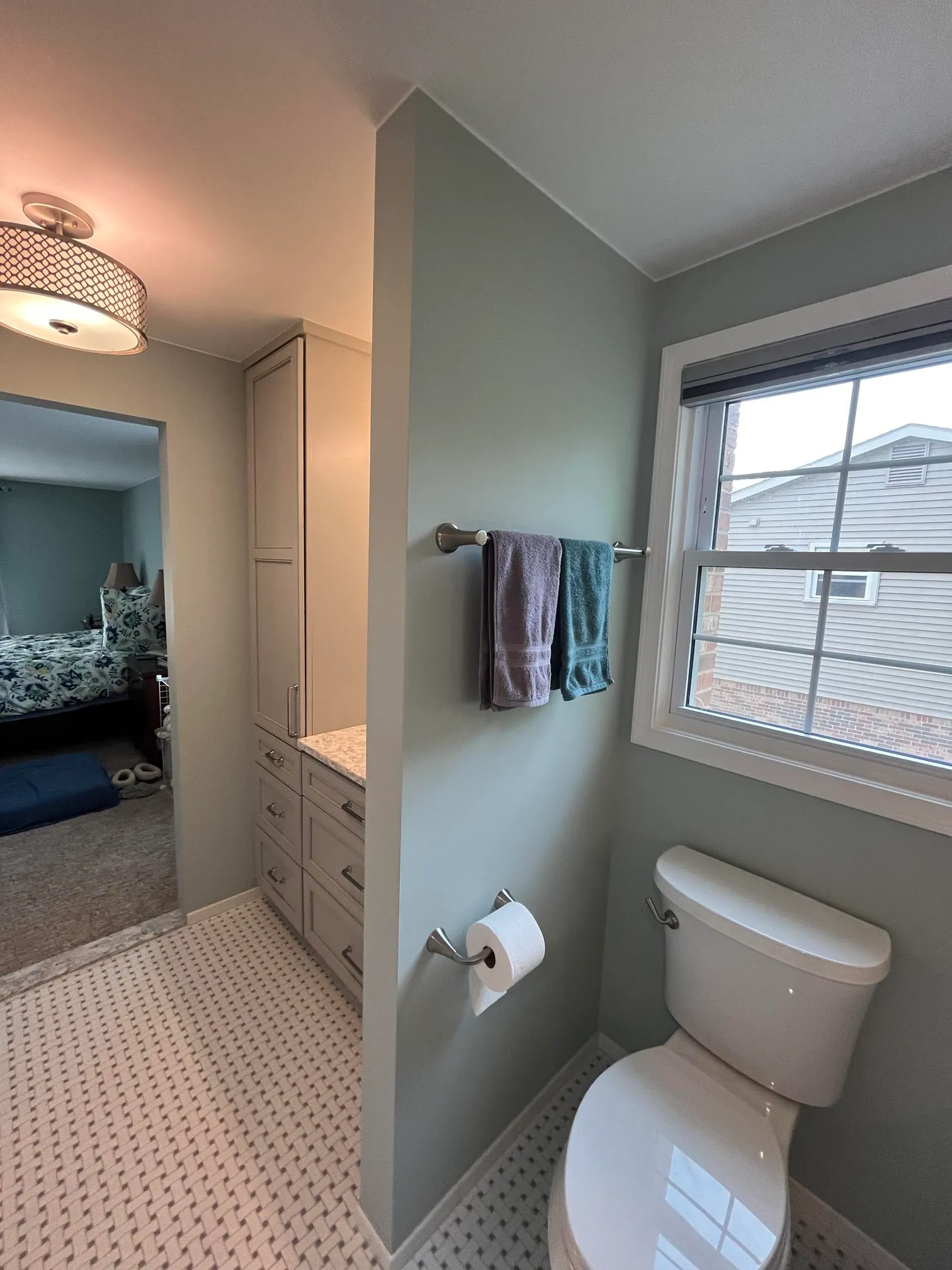 Modern bathroom featuring gray walls, a marble vanity, and a glass window with natural light.