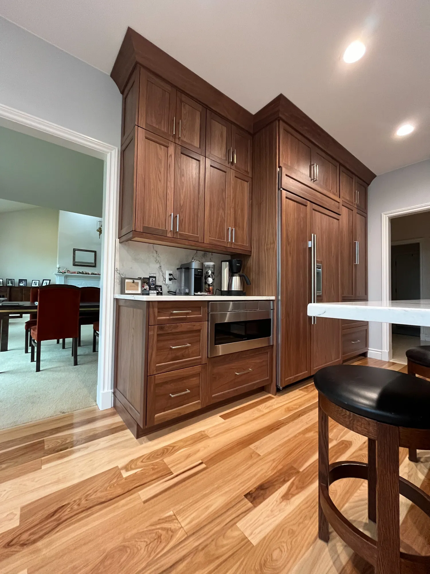 Modern kitchen in plymouth, michigan featuring custom wood cabinetry, stainless steel appliances, and hardwood flooring.