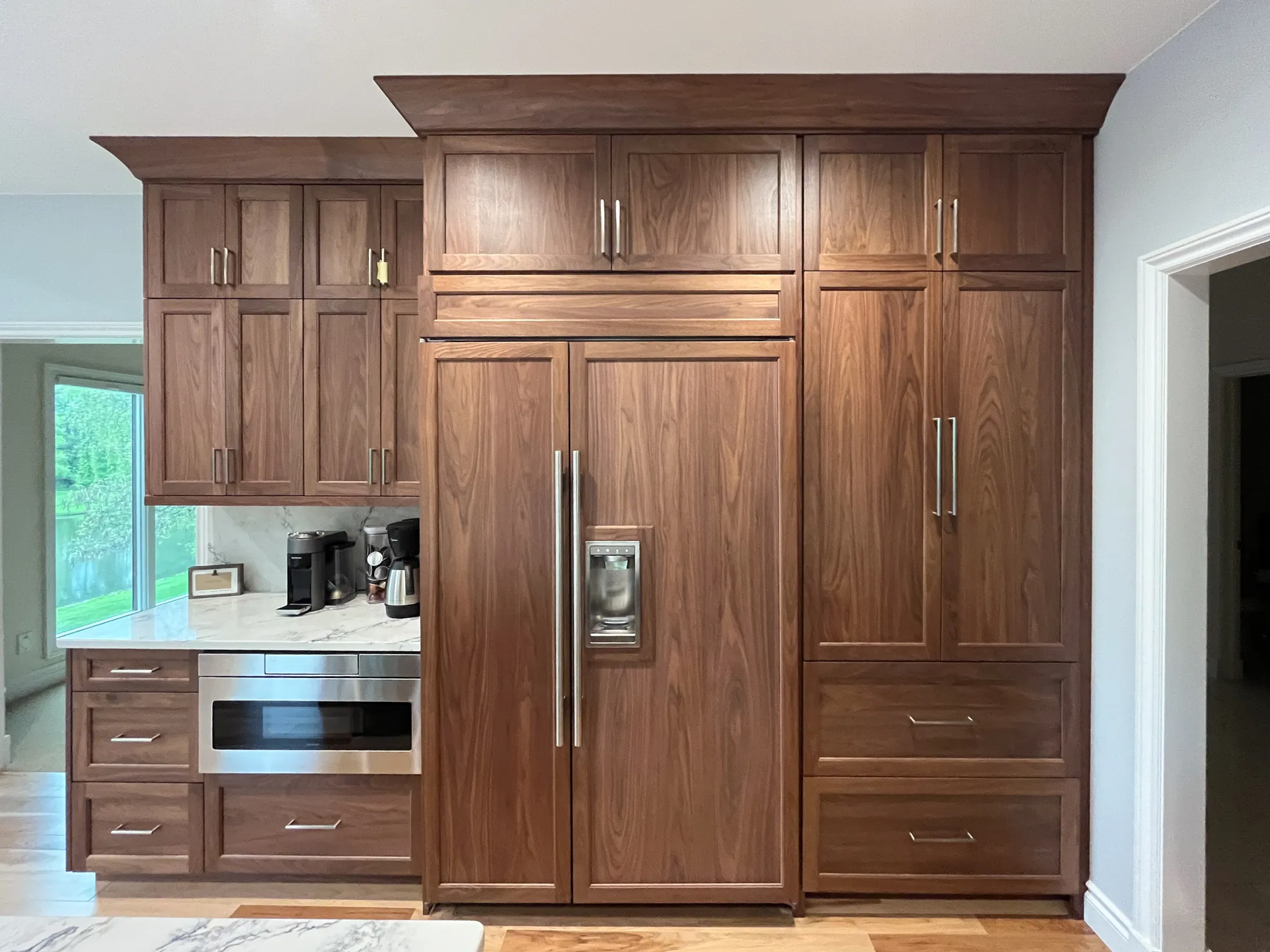 Contemporary kitchen in plymouth, michigan featuring walnut cabinets, a marble countertop, and stainless steel appliances.