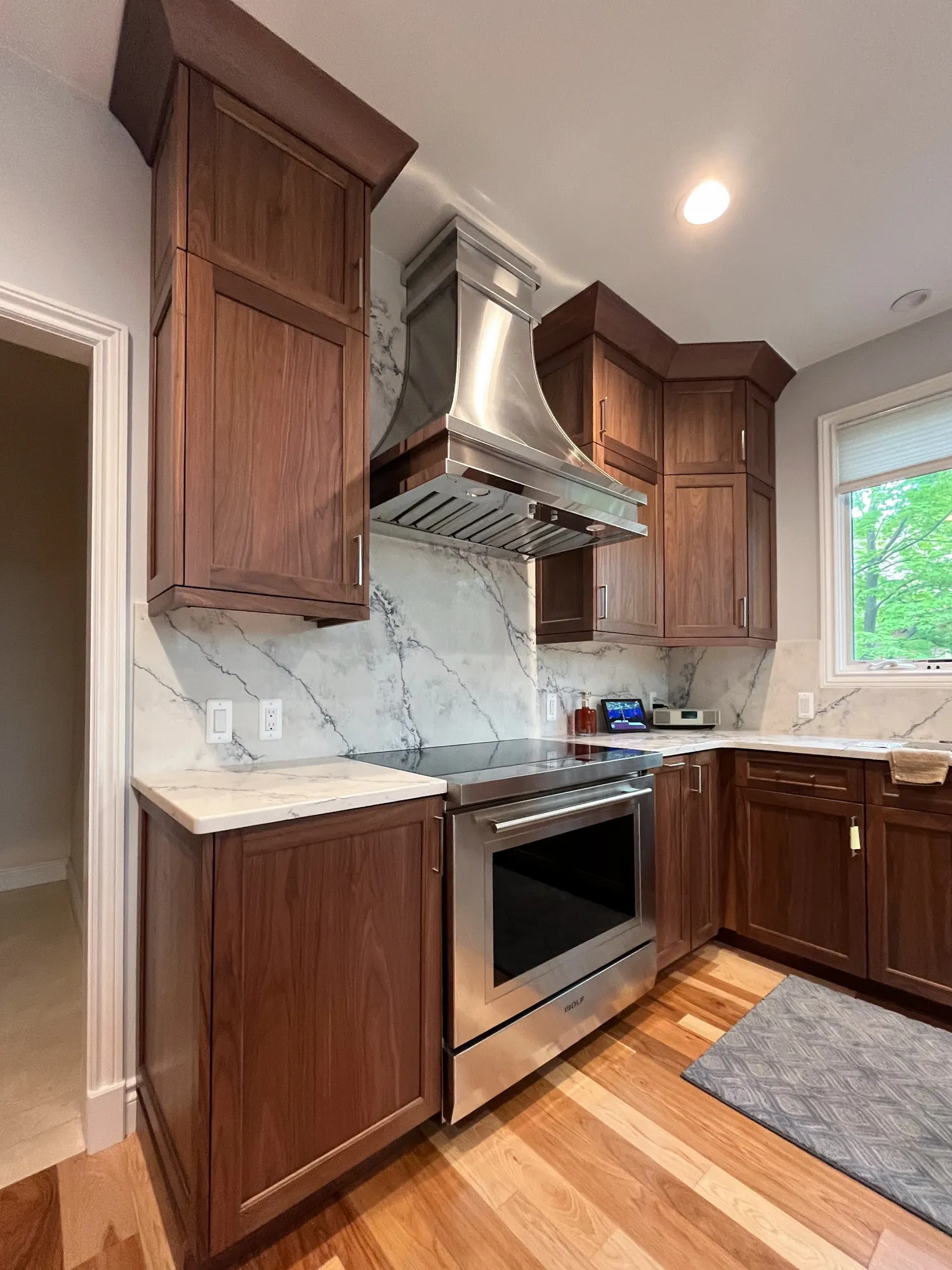 Modern kitchen in plymouth michigan with sleek stainless steel appliances, walnut cabinetry, and marble accents.