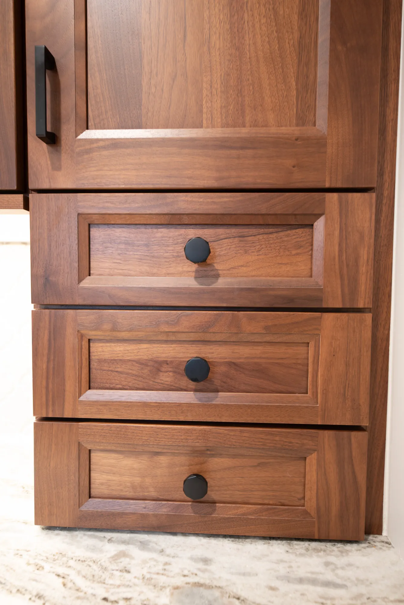 Modern bathroom vanity featuring walnut cabinets and black handles for a contemporary design.