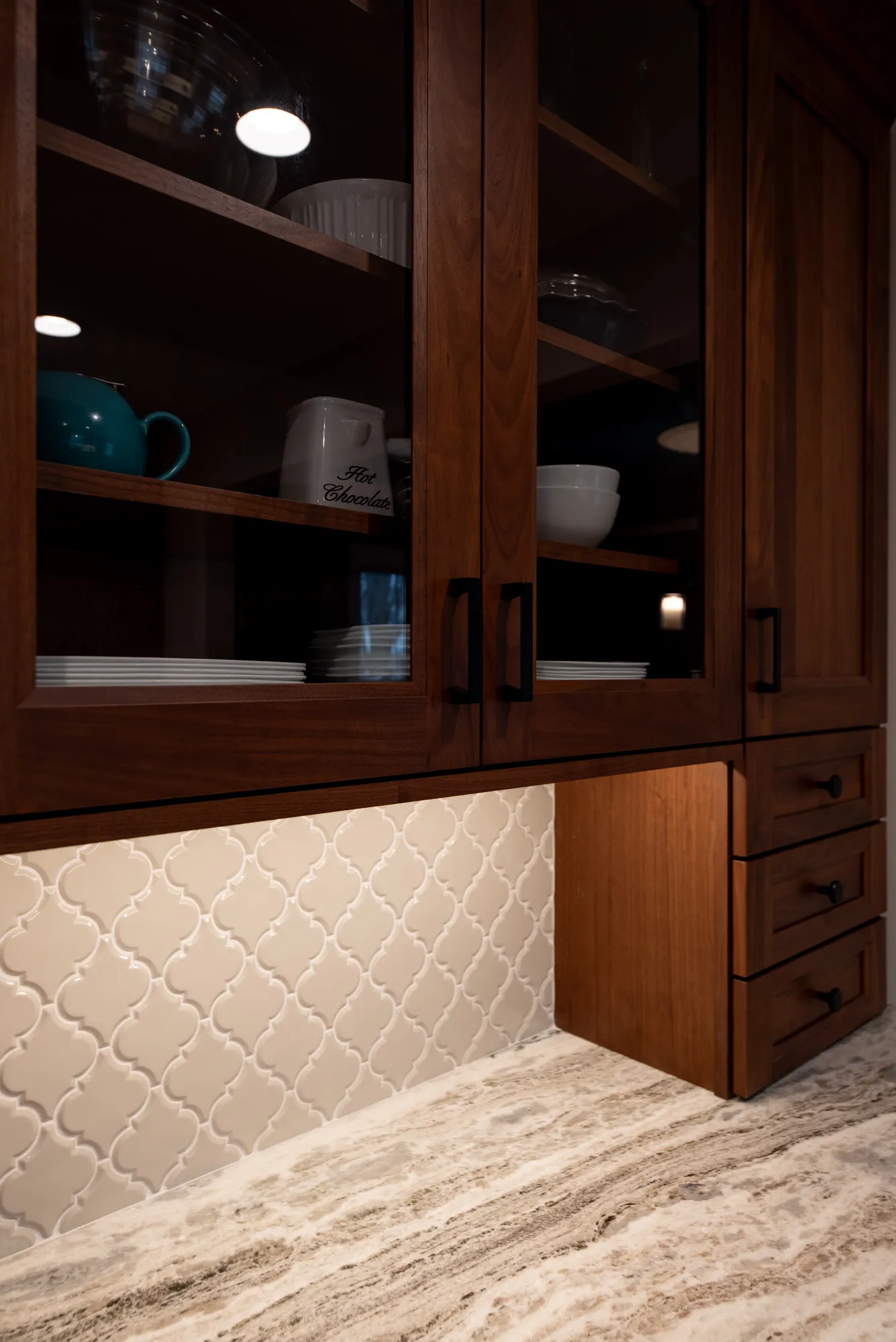 Contemporary kitchen with wooden cabinets, slate surface, and white patterned backsplash