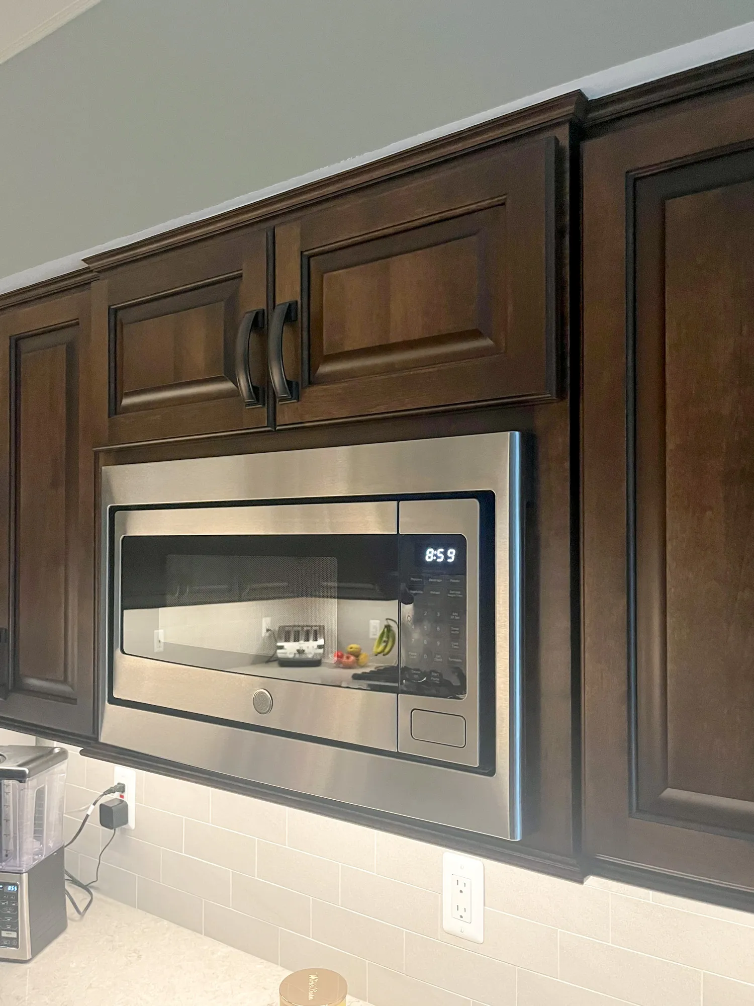 Modern kitchen in plymouth, michigan featuring custom wood cabinets and a stainless steel microwave