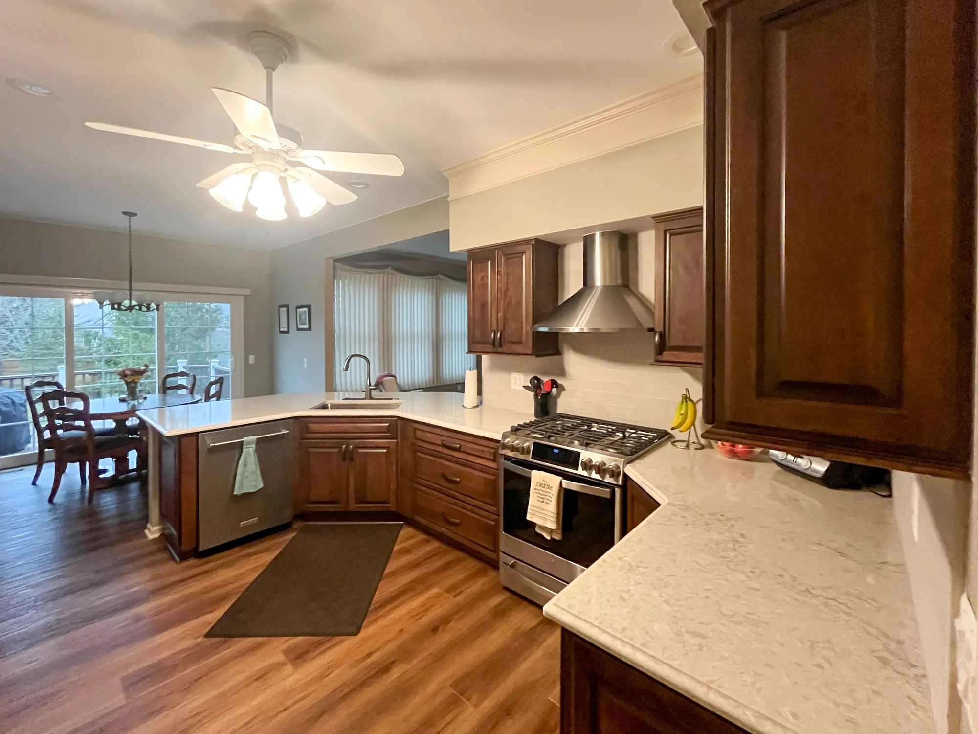 Modern kitchen featuring dark wood cabinets, marble countertops, and stainless steel appliances in plymouth
