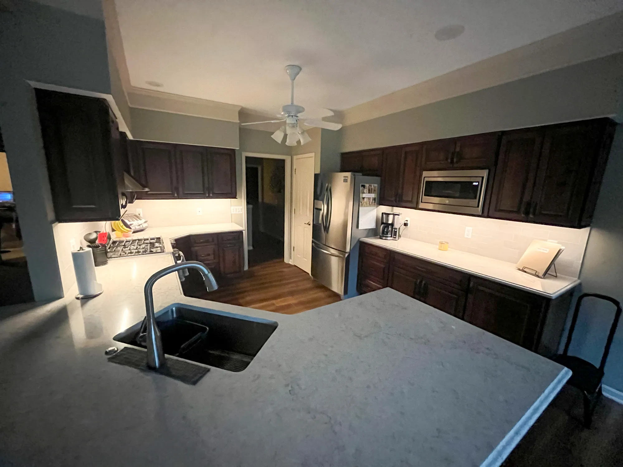 Modern kitchen with dark wood cabinets and under-cabinet lighting in plymouth, michigan