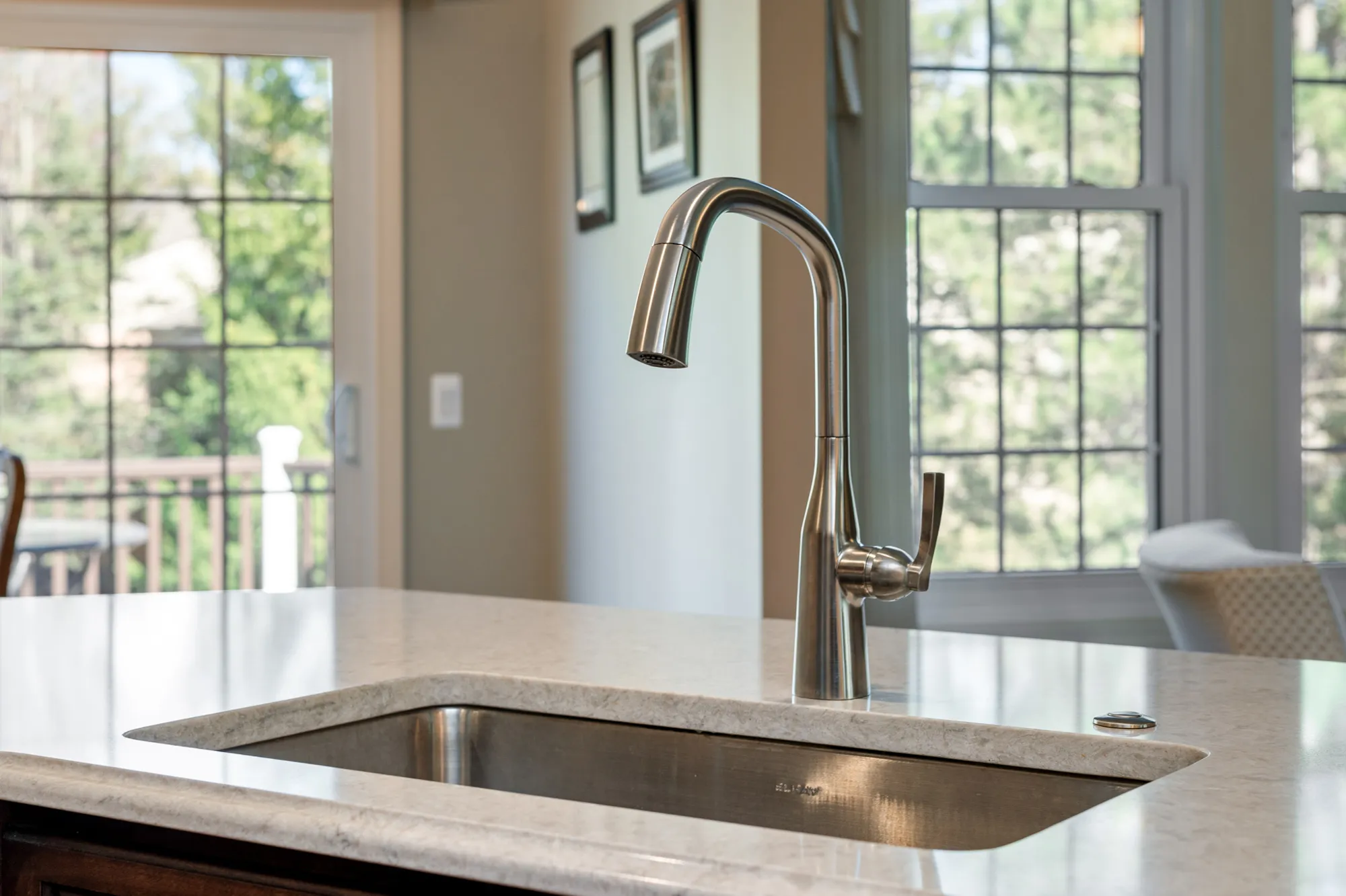 Modern kitchen sink with a sleek stainless steel faucet and light-colored countertop in a spacious Plymouth, Michigan home.