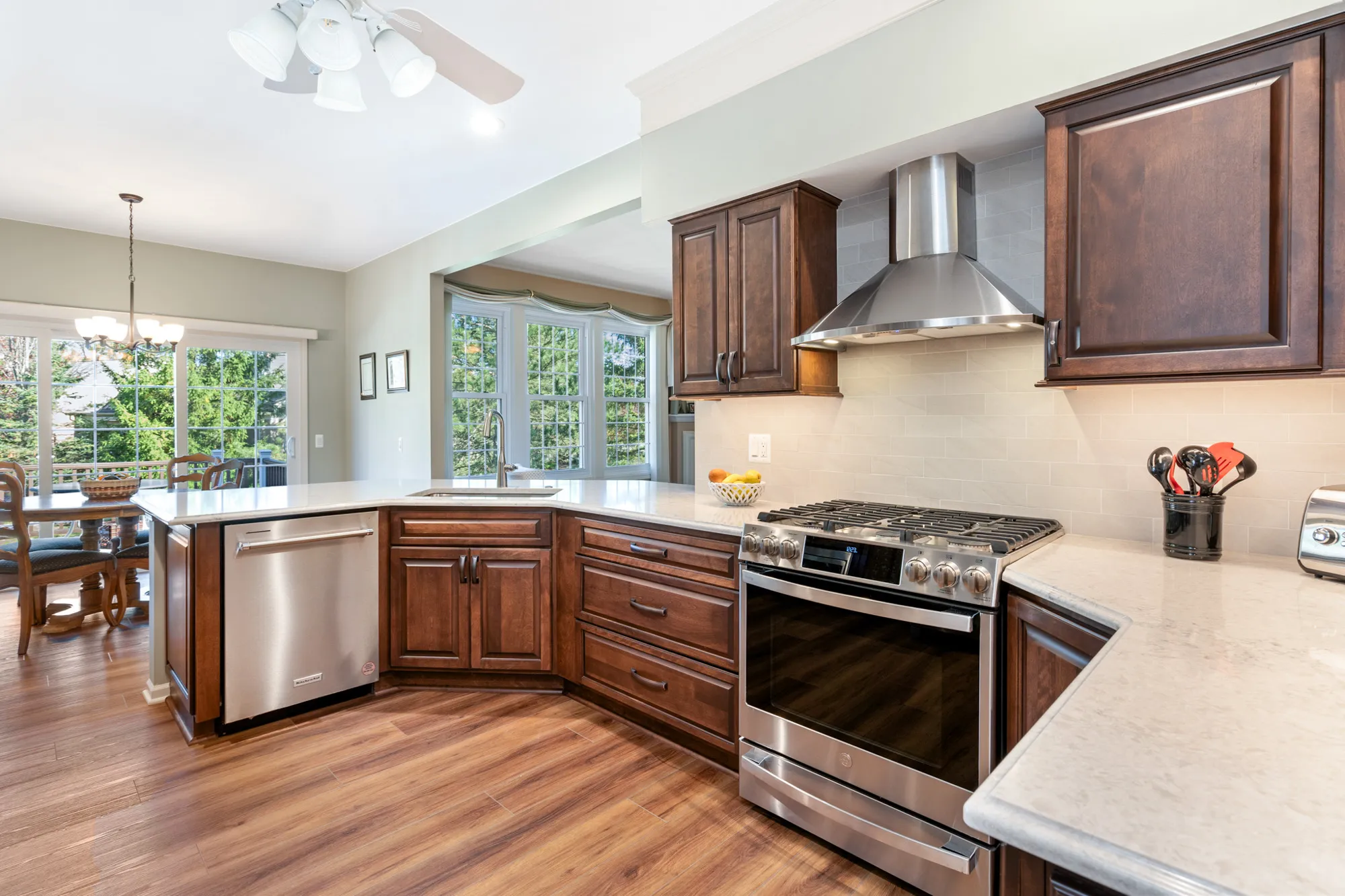 Modern kitchen in plymouth, michigan with quartz countertop and dark wood cabinets featuring stainless steel appliances.