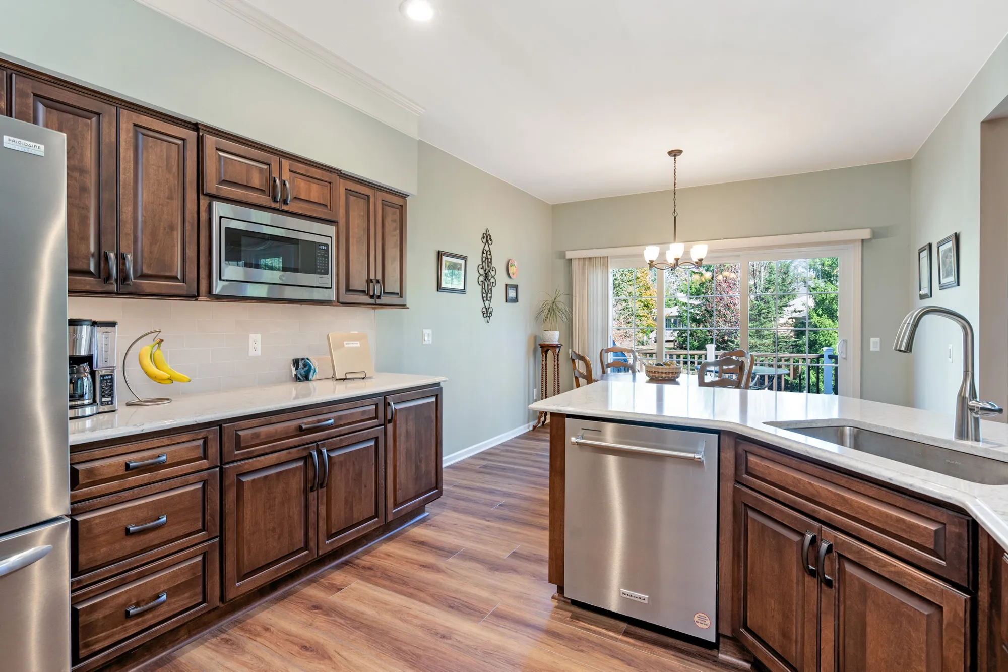 Modern kitchen renovation featuring dark wood cabinets, stainless steel appliances, and a spacious design in plymouth, michigan.