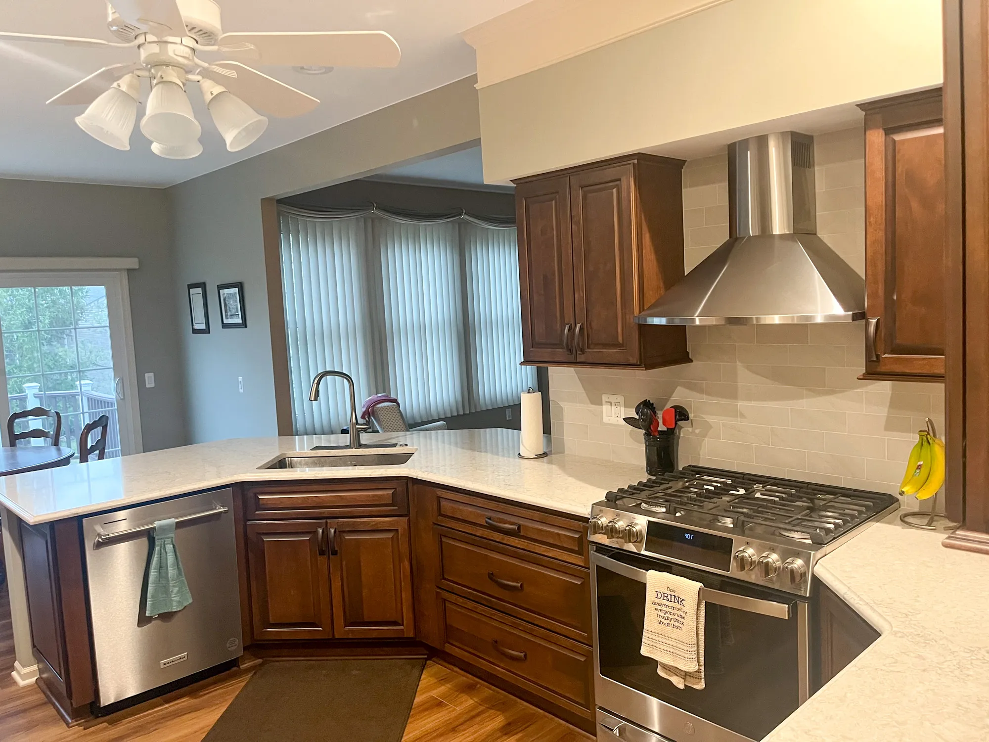 Modern kitchen featuring dark wood cabinets, stainless steel appliances, and a white countertop in plymouth.