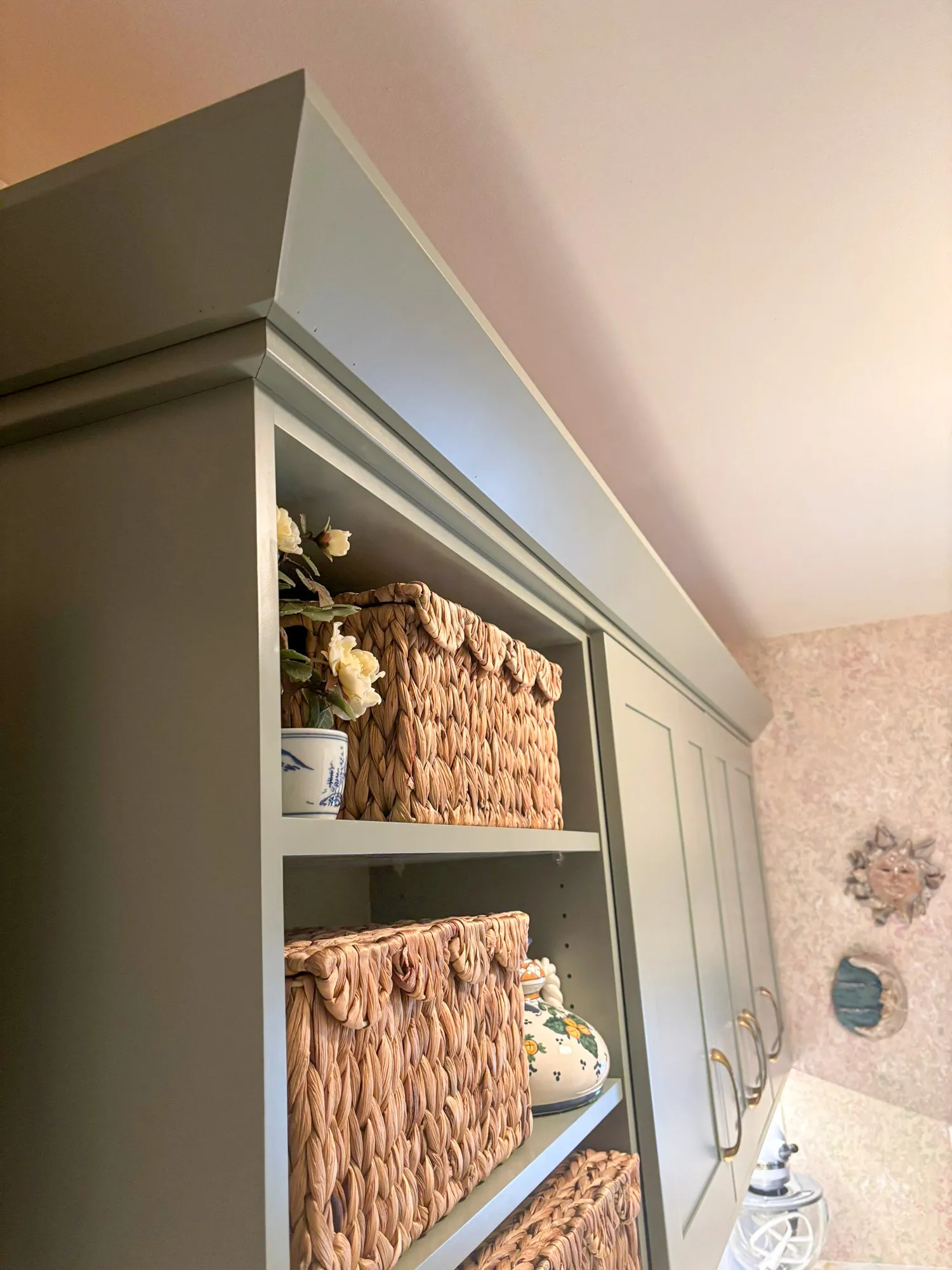 Stylish modern kitchen storage with woven baskets and decorative elements, featuring a neutral color palette.
