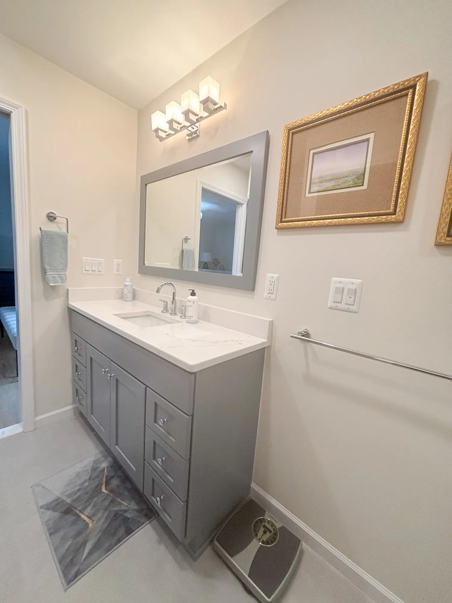 Contemporary bathroom with gray vanity, marble countertop, and elegant lighting