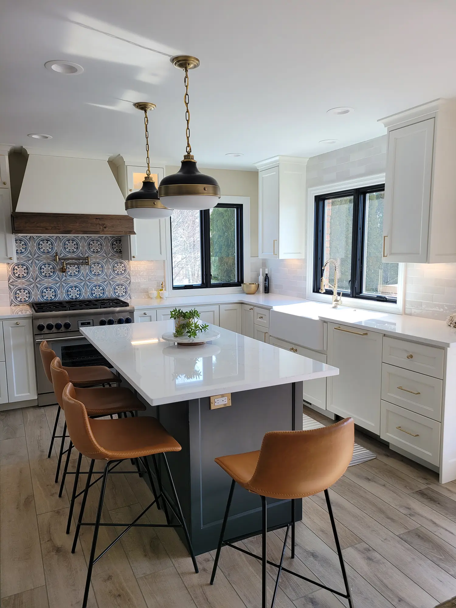 Kitchen with white cabinets, a large island, and tan bar stools.