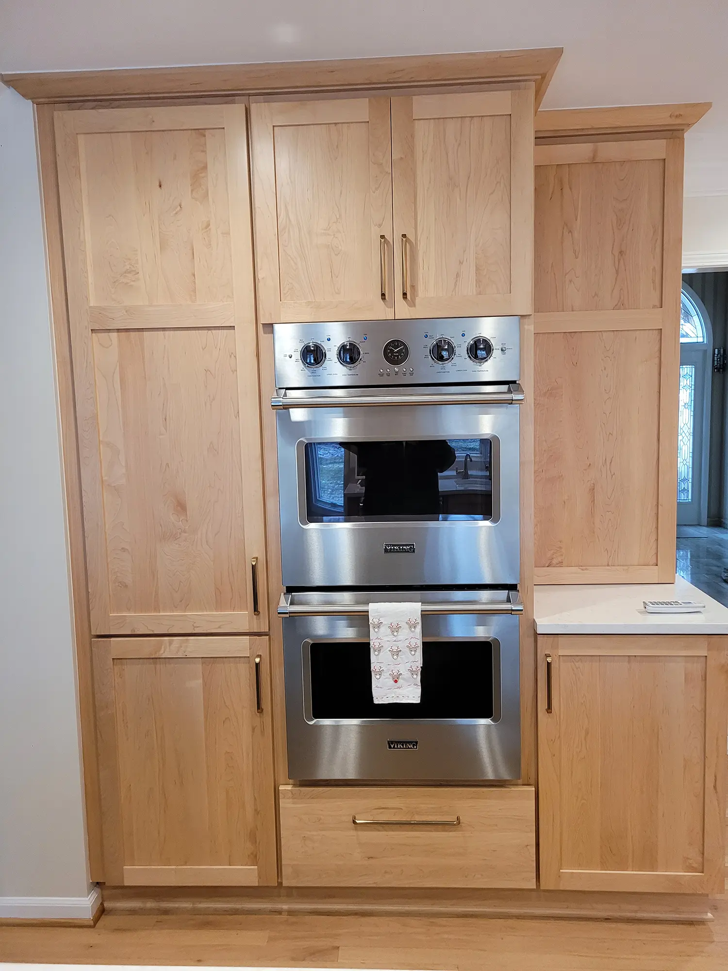 Built-in double oven with light wood cabinets