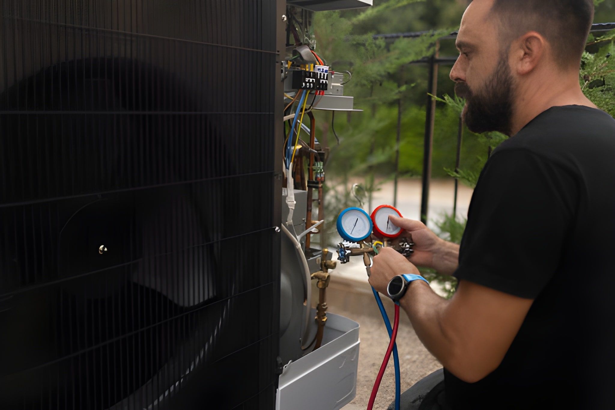 Technician checking pressure gauges on HVAC system outdoors