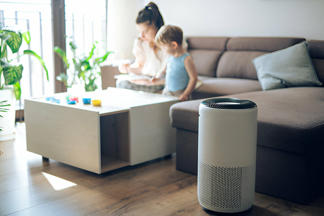 Air purifier in living room with parent and child playing nearby