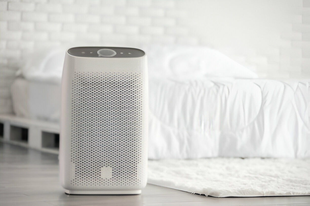 White air purifier on floor near white textile in minimalist room