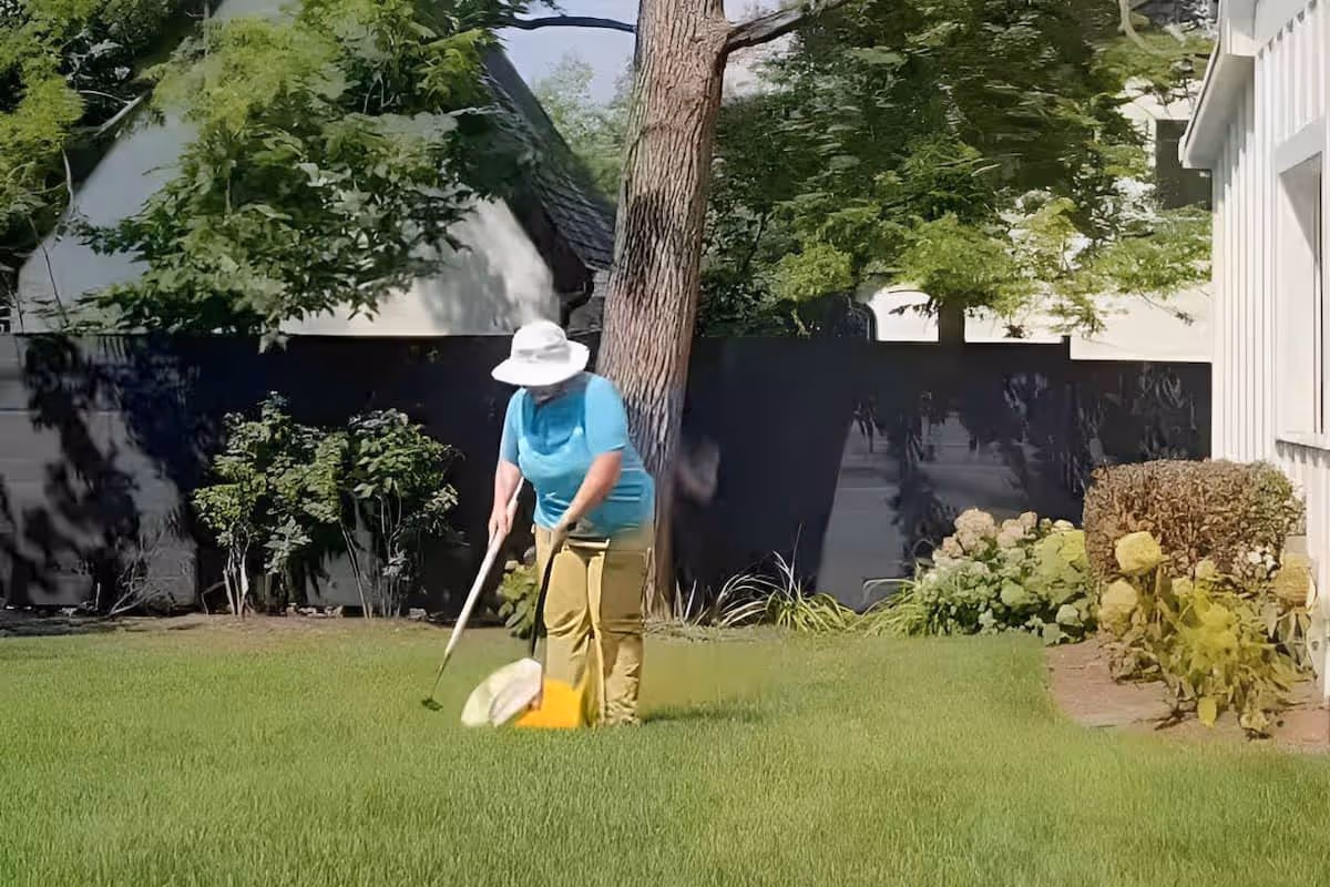 Doo Away technician scooping dog waste in a backyard