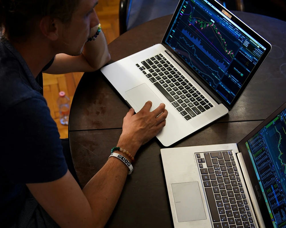 man working with multiple laptops in front of him