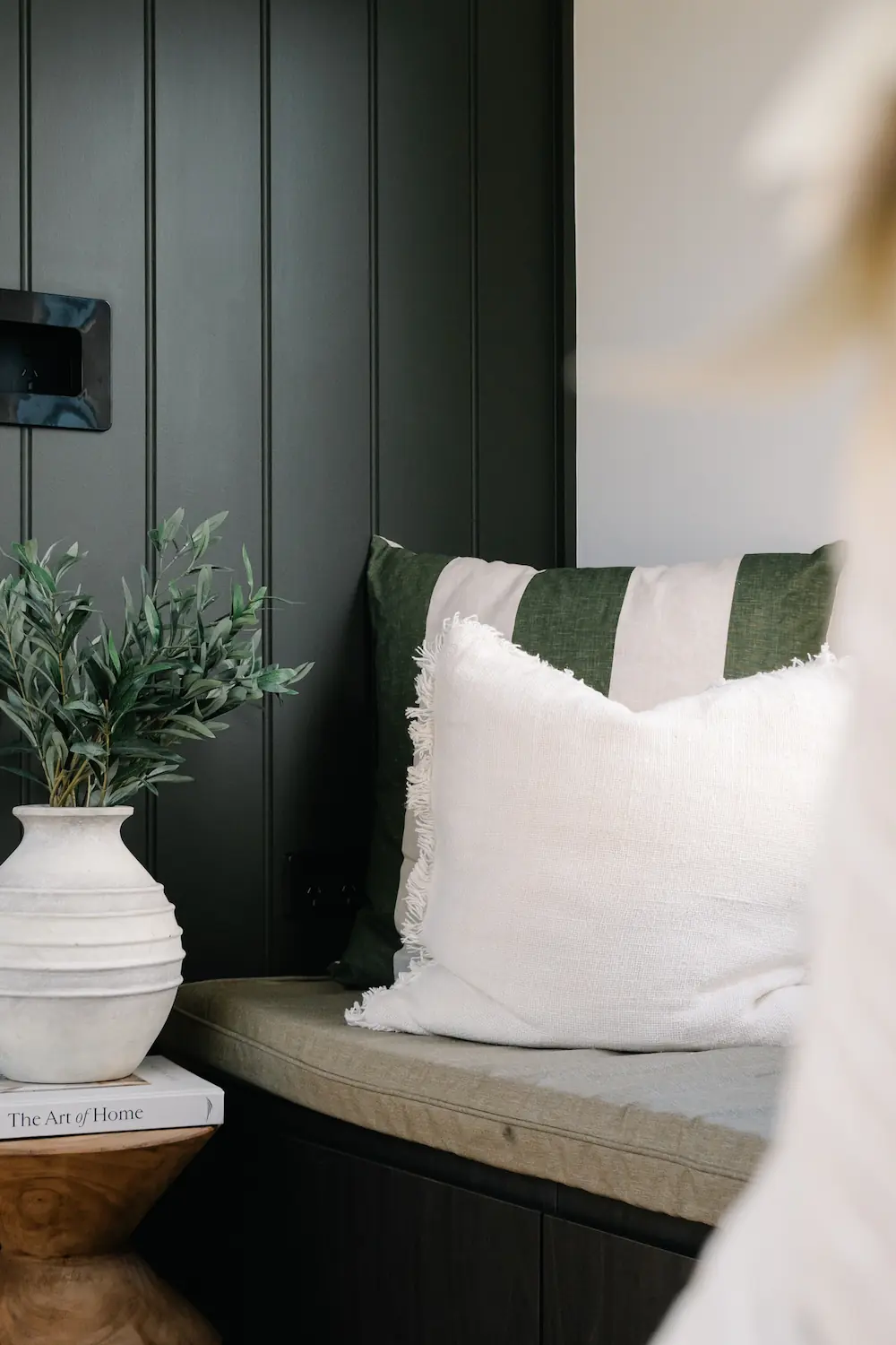 Interior of Tiny Home showing bench with cushions and plant on table