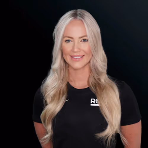 Smiling woman with long blonde hair wearing a black shirt against a black background.