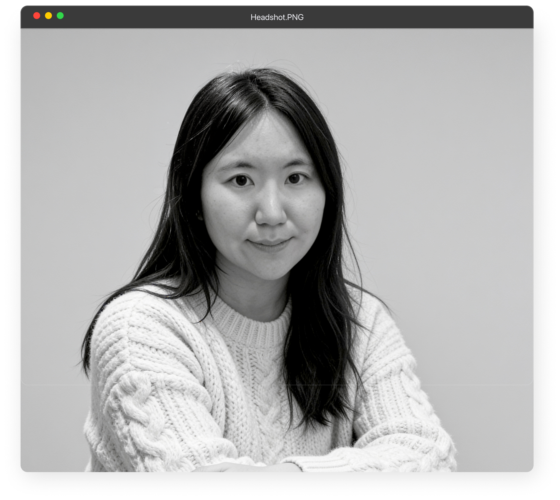 Black and white portrait of Michelle Ma, a smiling woman with long dark hair, wearing earrings and a necklace.