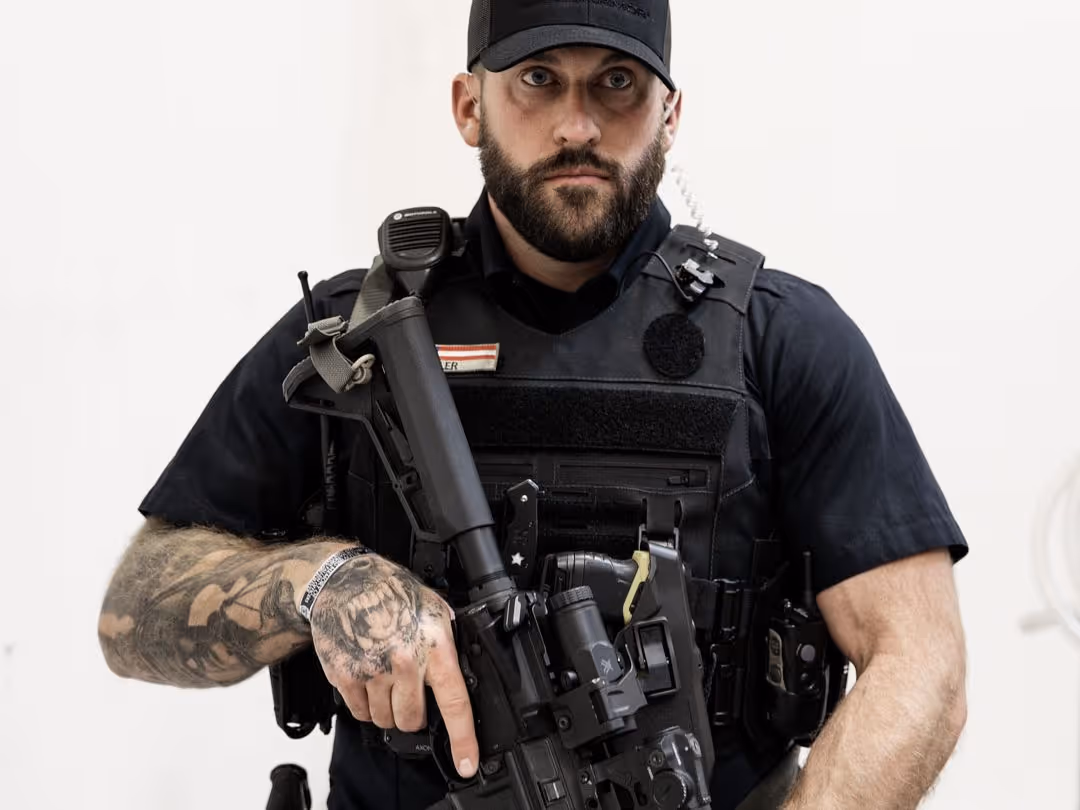 Officer gripping rifle in a ready position while wearing the Patrol Carrier 2.0, highlighting the carrier’s clean profile, equipment integration, and operational stability.