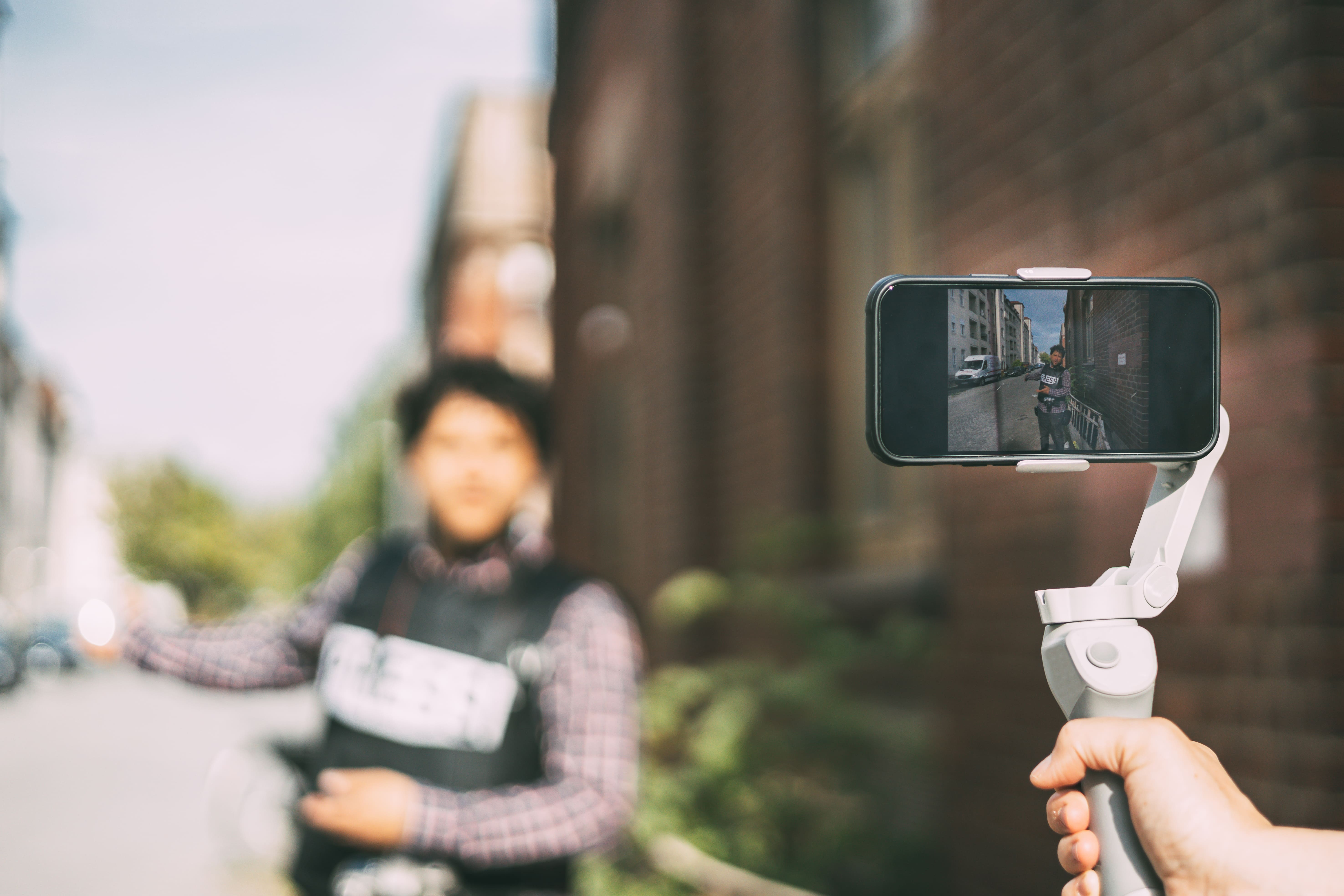 Glass jar filled with coins, stacks of coins, and bundles of paper money on a reflective surface with a dark background.