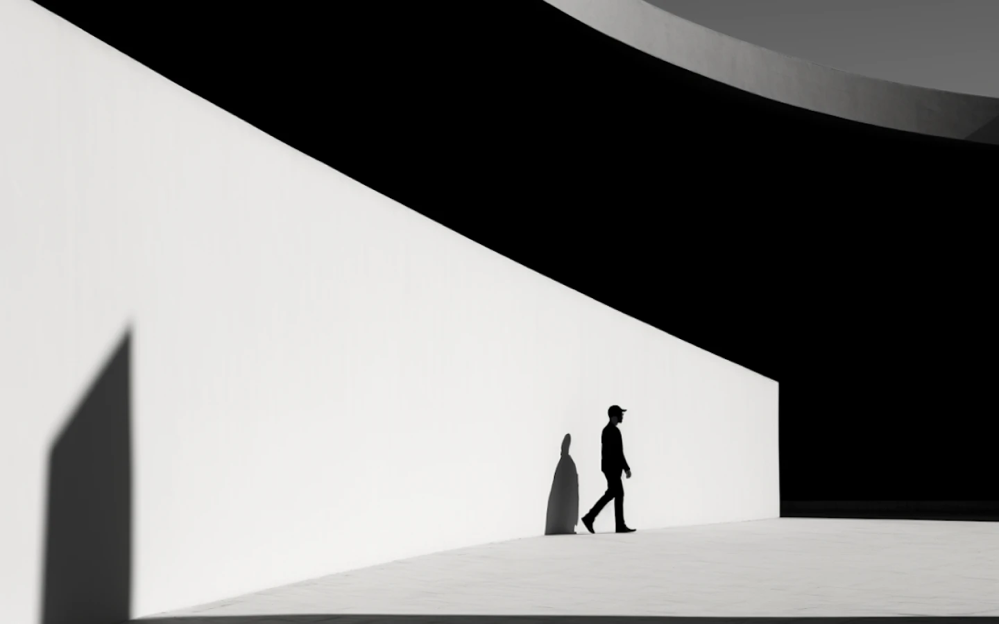 Two people walking beside a large angular white structure casting strong geometric shadows.