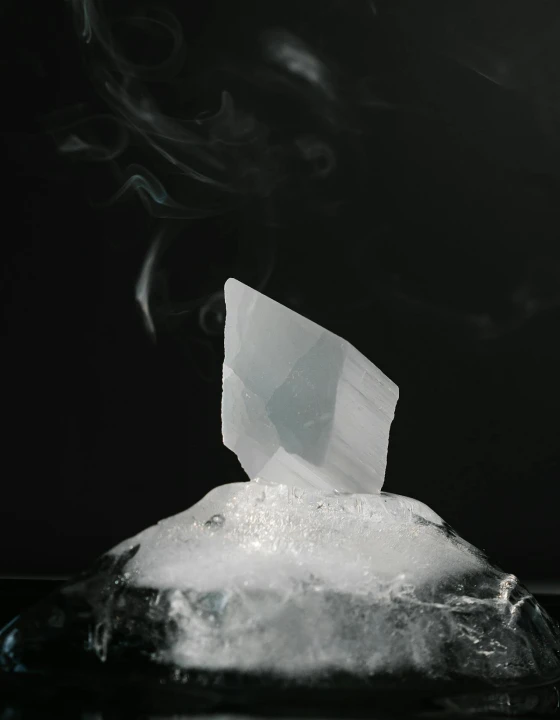 Large block of ice illuminated against a dark, moody background.