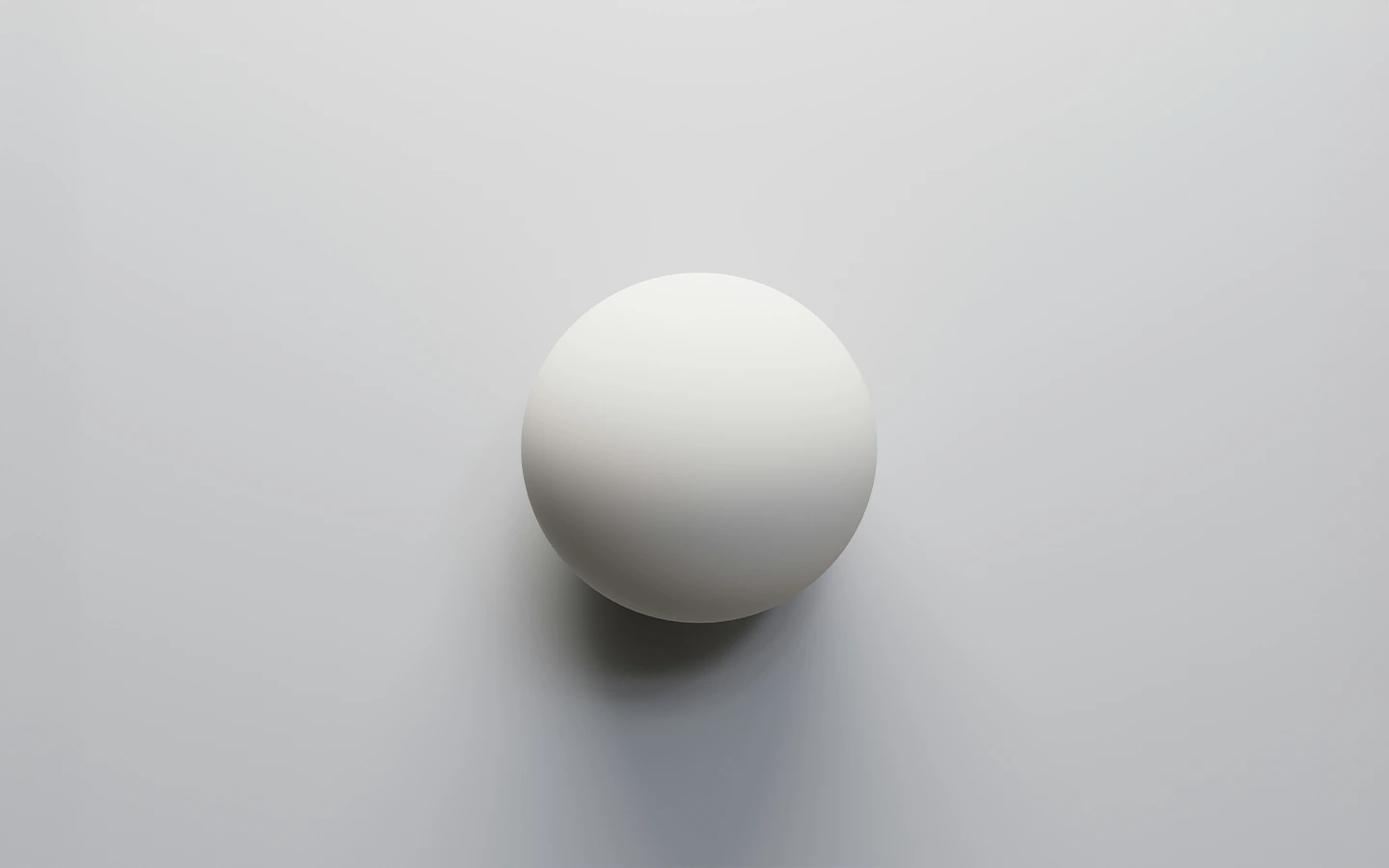 White sphere casting a soft shadow on a light gray background.
