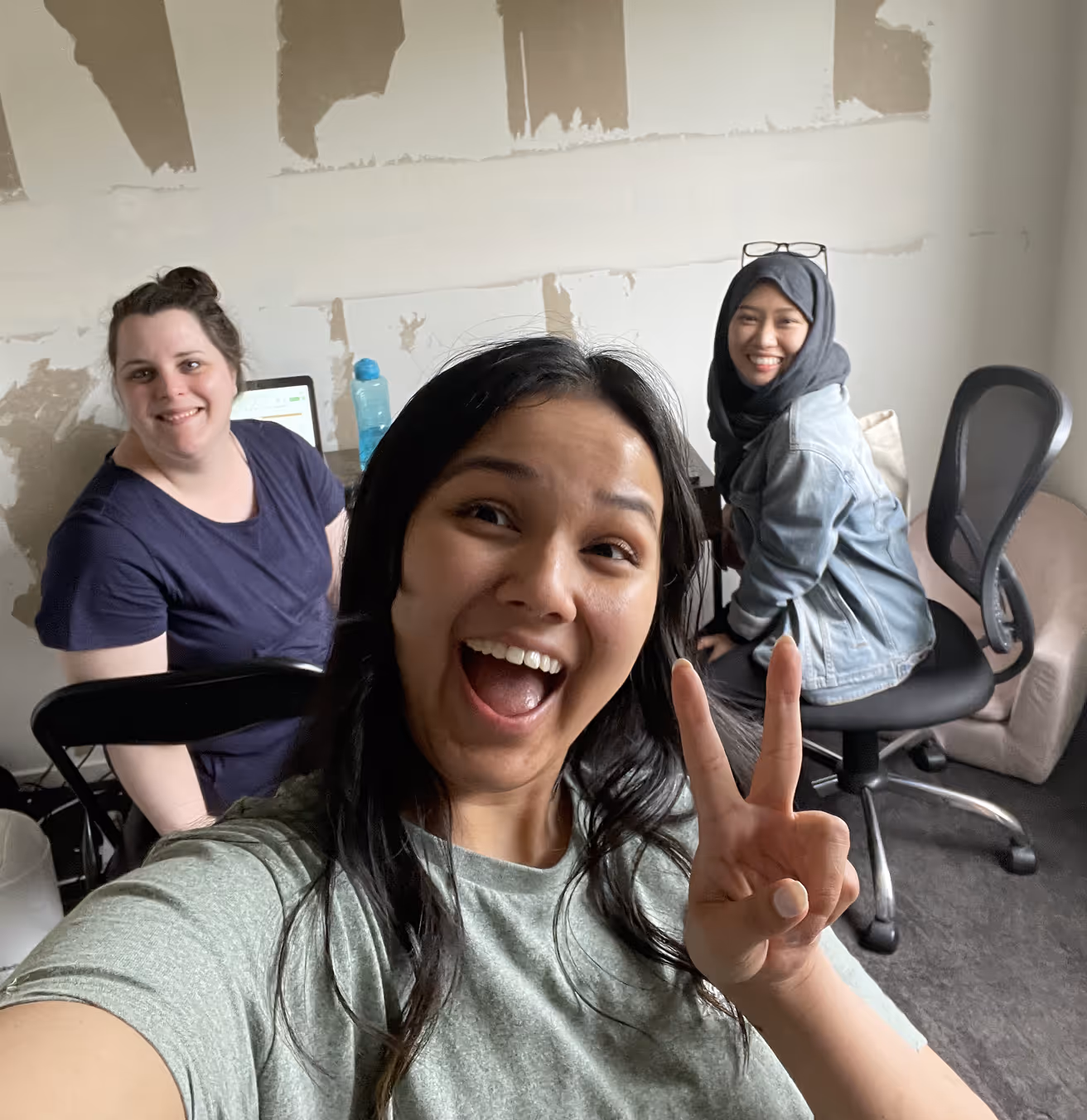 Three women posing in front of a camera.