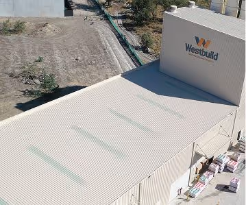 Aerial view of Westbuild warehouse with logo on the side and building materials stacked outside.