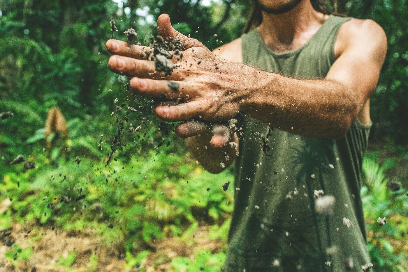 Farmer holding and examining soil in a field.