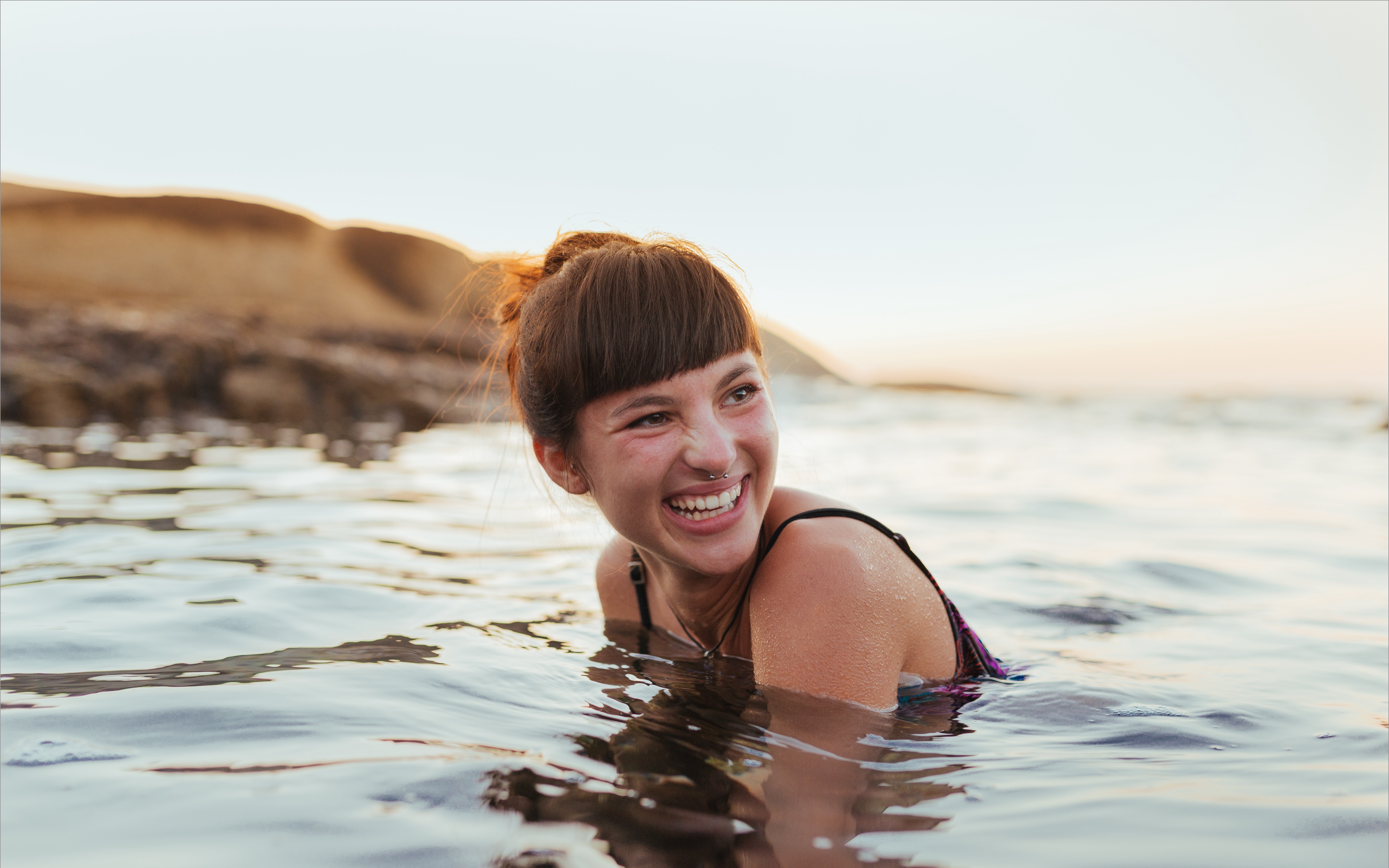 Woman smiling while swimming in the ocean.