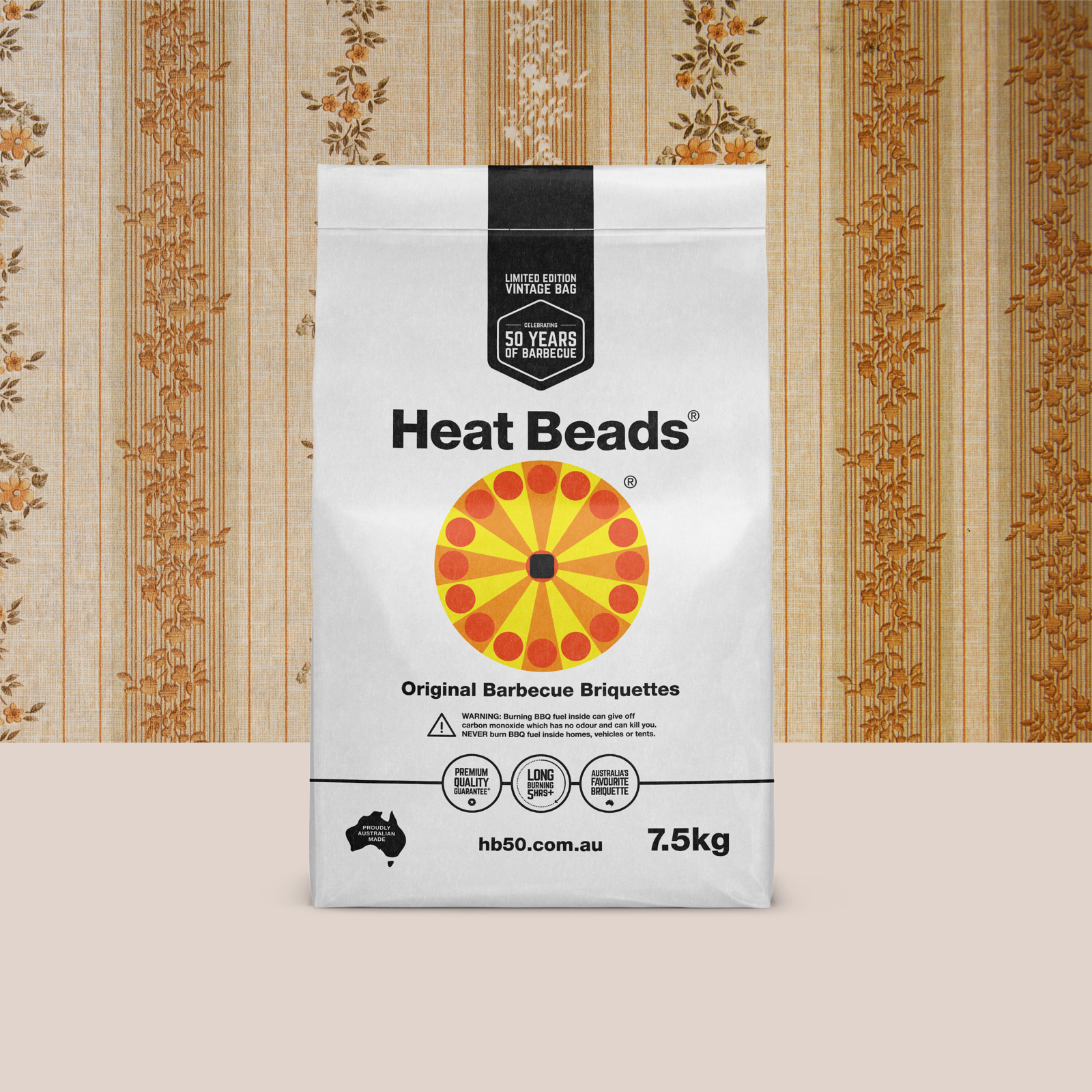White vintage Heat Beads briquettes bag on a cream surface and in front of old-fashioned brown wallpaper.