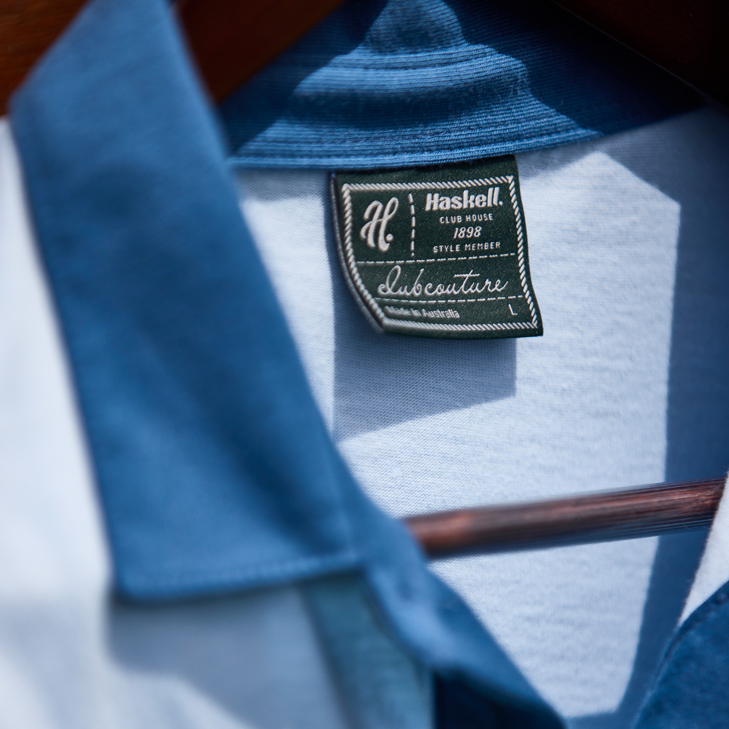 Close up of Haskell label on the collar of a blue polo shirt.