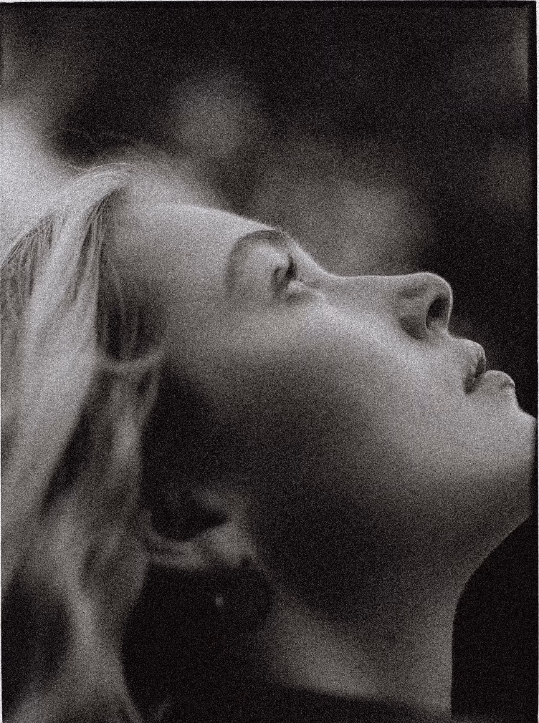 Black and white close-up portrait of a woman’s face in profile looking upward.