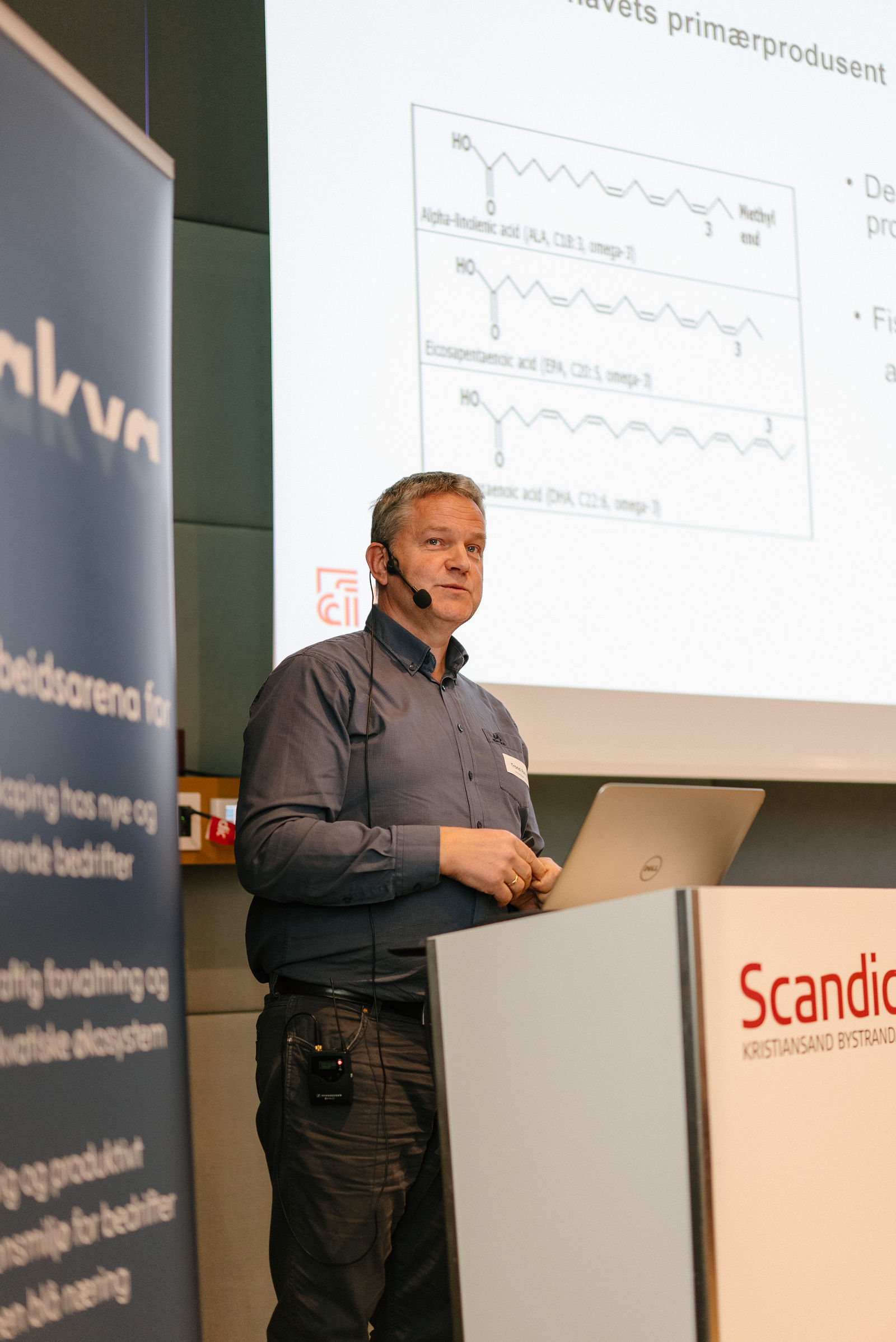 Trond Rafoss fra Universitetet i Agder holder innlegg foran en plansje om omega-3-fettsyrene ALA, EPA og DHA.