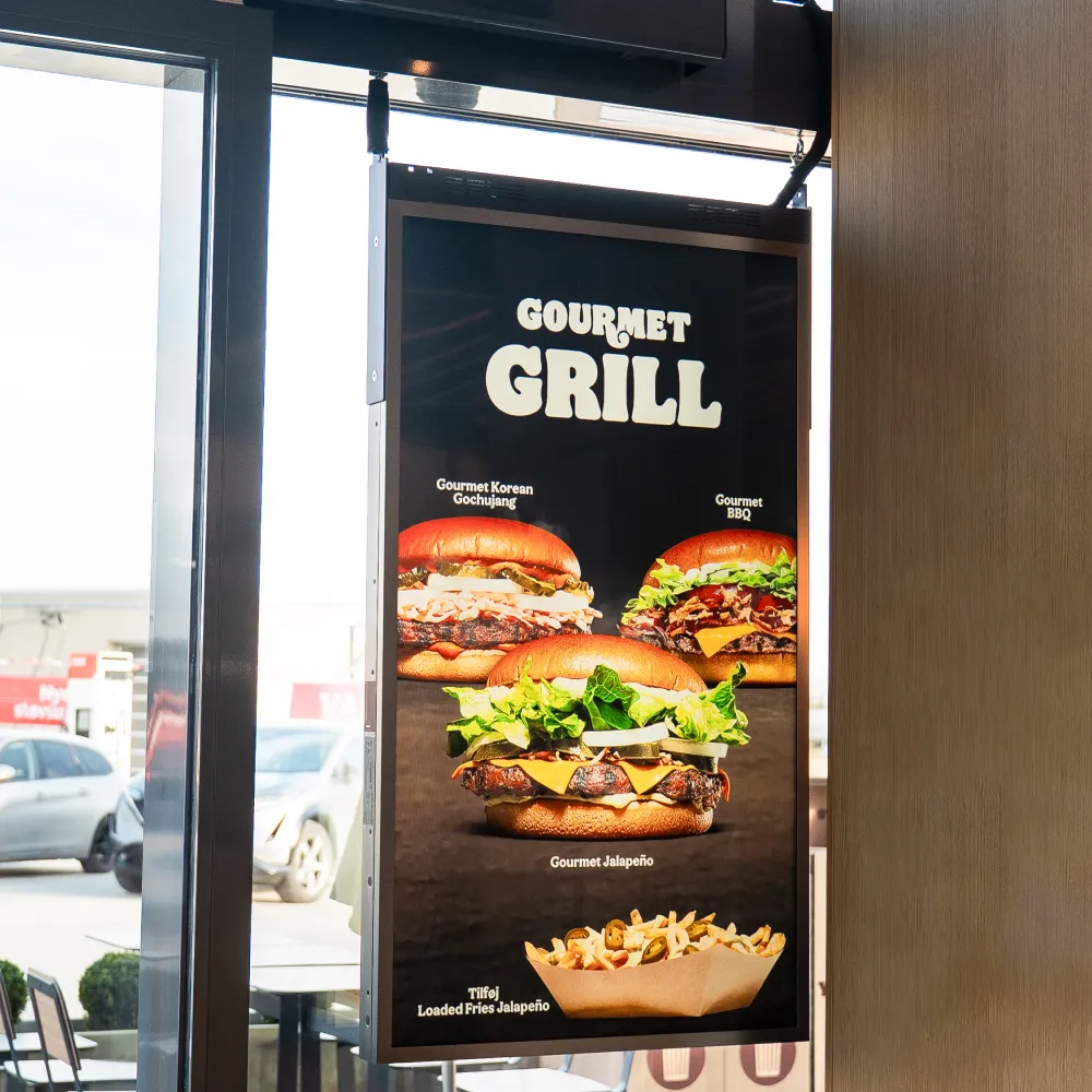 Digital menu board displaying gourmet grilled burgers named Korean Gochujang, BBQ, Jalapeño, and a serving of loaded fries with jalapeños.