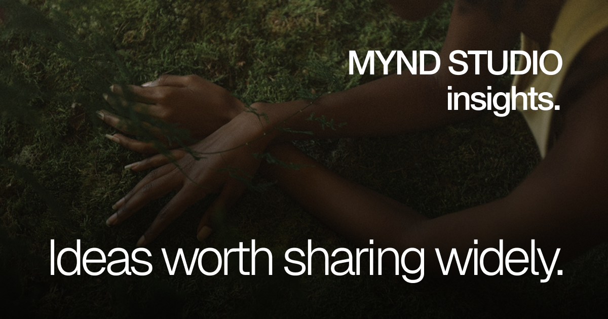 Person with dark skin lying on green moss with hands crossed, overlaid with text: MYND STUDIO insights. Ideas worth sharing widely.
