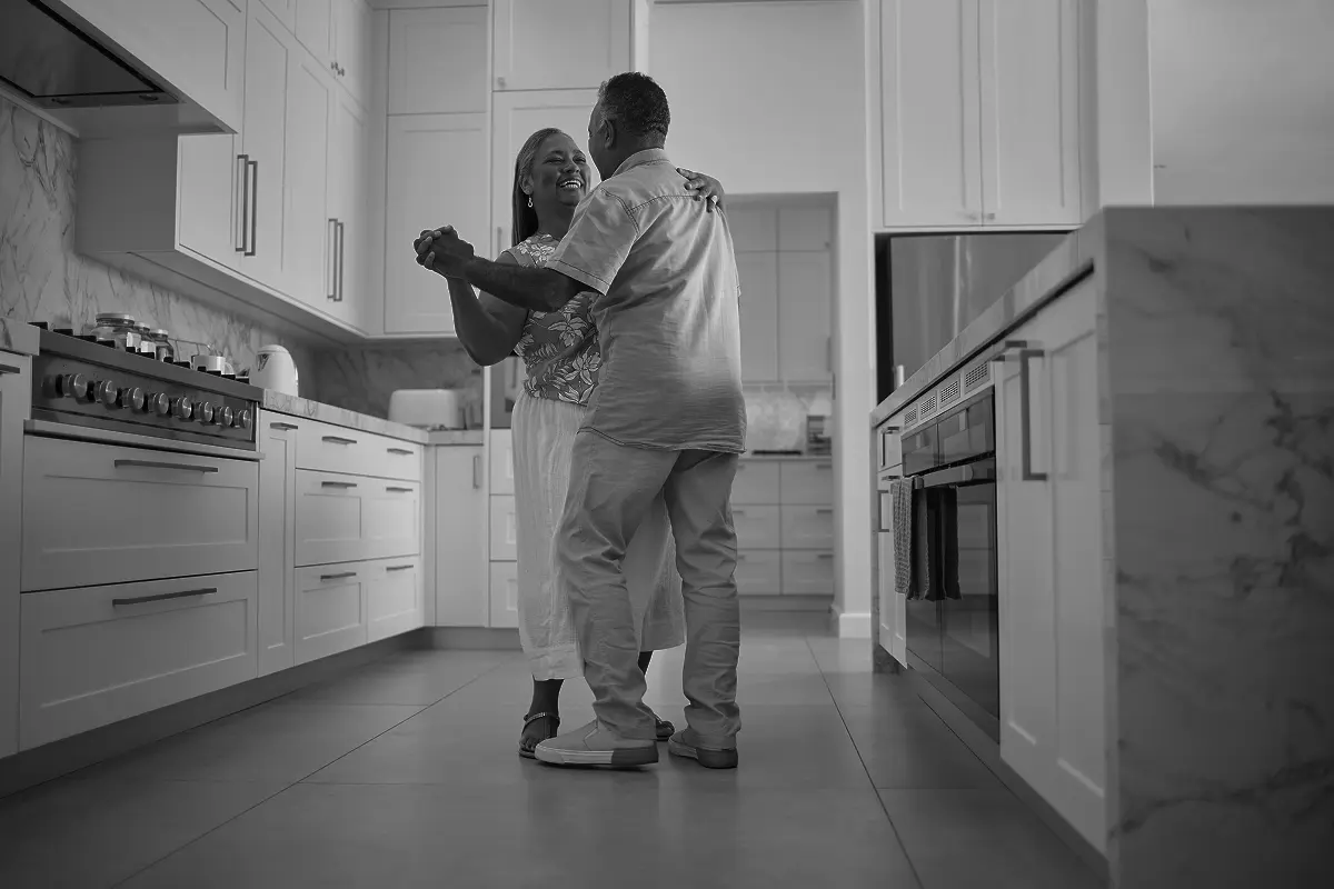 Confident woman in a blazer looking upward with blurred tall building in the background.