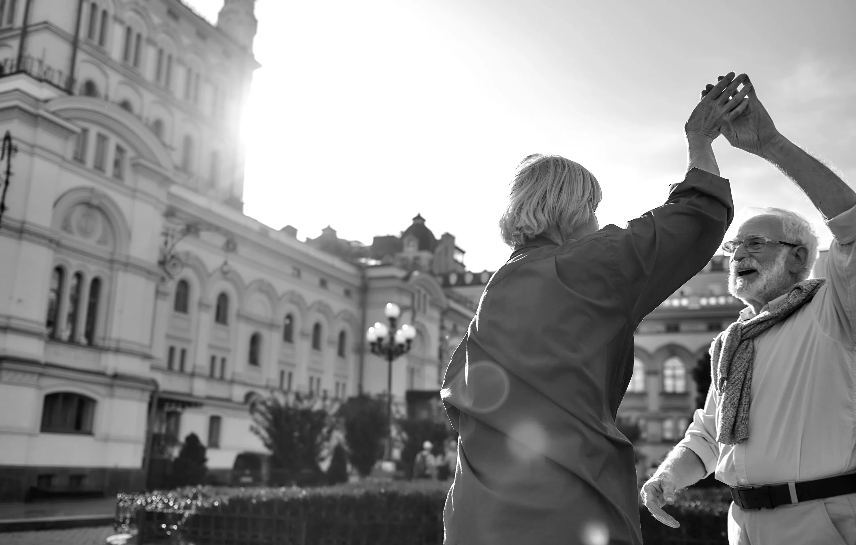Smiling older couple dancing together outside