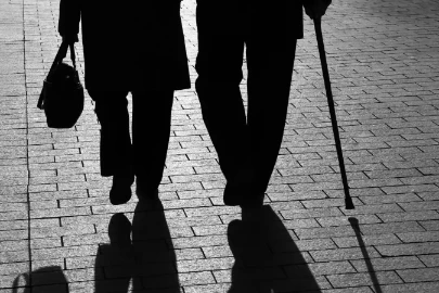 shadows of retired elderly individuals walking on stone street