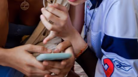 Close-up of two people looking at phone together