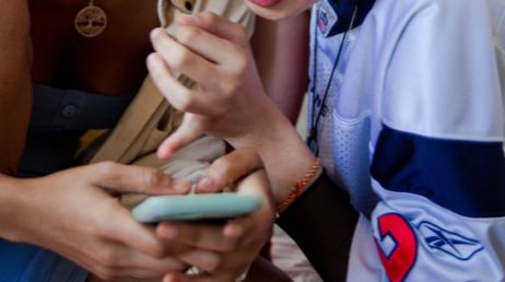 Close-up of two people looking at phone together