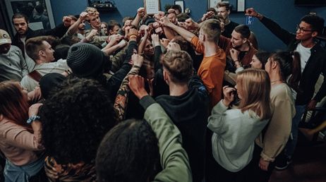 Group of people raising fists in unity at a gathering