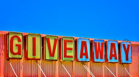 Brightly colored GIVEAWAY sign against blue sky