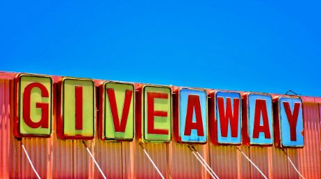 Brightly colored GIVEAWAY sign against blue sky