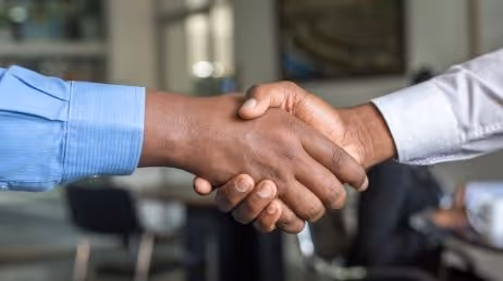 two people shaking hands in business meeting