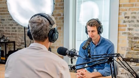 Podcast hosts recording an interview in a studio